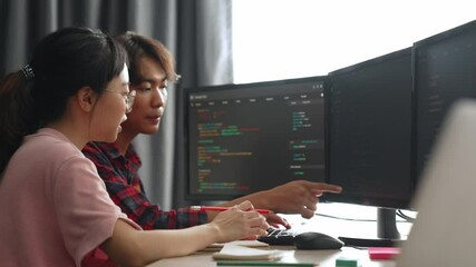 Slow motion back end software developer engineer for computer programming working together on debugging writing computing code, solving complex algorithms display on monitor in office. Burgeoning