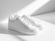 © Gendis Studio - Pair of white, lace-up sneakers on a white surface, in bright light.