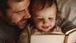 © Z A C - A father and a baby are reading a book together in a cozy dimly lit setting.