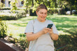 © mdyn - Happy woman chatting on phone and relaxing outdoors. Urban people concept. Smiling woman text messaging on smart phone at sunny day.