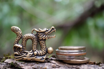 Wall Mural - A metal dragon figurine with coins.