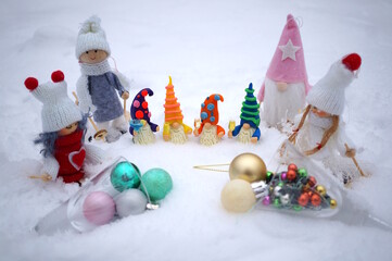 Wall Mural - Fabulous toy characters in the winter forest. Four dwarfs with glasses of champagne and Christmas angels. Next to it are two glasses with Christmas balls.