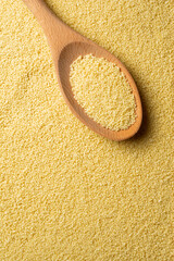 Wall Mural - Couscous grains scooped up by a wooden spoon