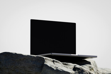 Wall Mural - scene with a opened laptop with a blank screen on the rock
