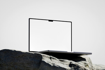 Wall Mural - scene with a opened laptop with a white blank screen on the rock