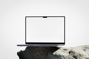 Wall Mural - scene with a opened laptop with a white blank screen on the rock