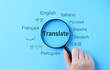 © Supatman - Translation and Multilingual Communication Concept. A magnifying glass highlights the word 'Translate,' surrounded by names of multiple languages, multilingual translation, and global communication.