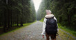 © RecCameraStock - Back view of female hiker with backpack rambling through the foggy woods. Equiped tourist admiring nature. Travelling concept.