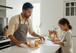 © Running opossum - Father wearing apron preparing healthy food and daughter drawing with colored pencils in modern kitchen
