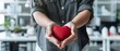 © Ai Studio - Hands extend forward offering a plush red heart, symbolizing kindness, love, and compassion in a modern setting.