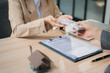© Wicitr - Real Estate Transaction: A close-up shot of a real estate agent handing over a stack of cash to a client, representing a successful property purchase or investment.