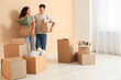 © Pixel-Shot - Young couple with cardboard boxes in their new flat