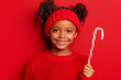 © Carmen - African-American  little girl wearing red sweater and holding candy cane for Christmas