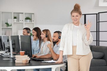 Wall Mural - Female technical support agent showing OK in office