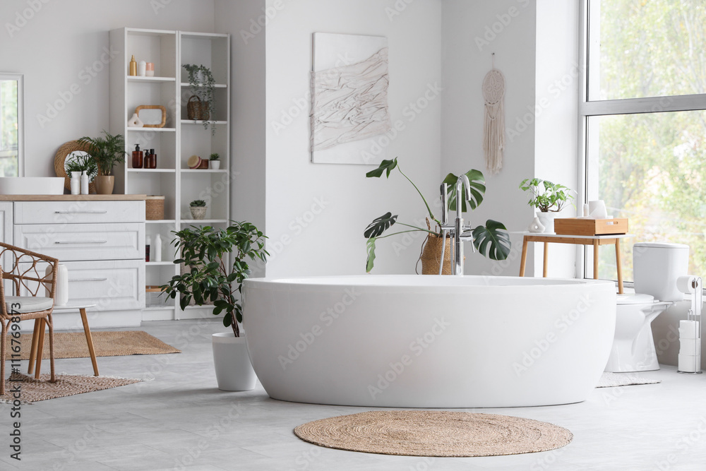 Interior of light room with white bathtub and plants