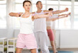 © JackF - Portrait of young energetic sporty woman standing and perform exercise with resistance bands in light pilates studio