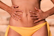 © Lucas Ottone/Stocksy - Close up of squeezed belly skin in a woman with diastasis