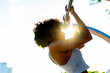© Raymond Forbes LLC/Stocksy - Young healthy black athlete doing pull up with sun flare