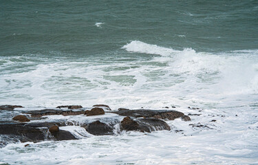 Wall Mural - Waves crashing over rocks ocean rough east coast new zealand oamaru