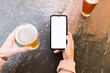 © Ibai Acevedo/Stocksy - Drinking beer using white screen phone