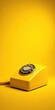 © Patthama - Yellow telephone receiver with a metallic finish on a dark yellow background, distressed yellow phone, retro yellow decor, metallic yellow phone