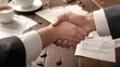 © Chainarong - Trust building close-up of a business handshake over a wooden table