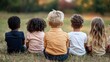 © pattaphorn - A group of diverse children sitting together on a grassy field, enjoying a sunset, embodying friendship, connection, and the innocence of childhood in a serene landscape.