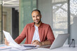 © Liubomir - A cheerful businessman is seated at his desk, reviewing documents with a smile. The scene depicts a professional office setting, emphasizing productivity and positivity.