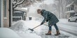 © Pak - Person Shoveling Snow from a Driveway During Winter Representing Seasonal Activities and Outdoor Work