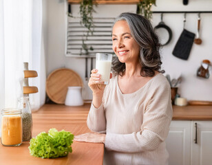 kitchen woman healthy morning mature grey hair during breakfast active fitness lady holding milk drink drinking glass