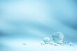 © Anna - Blue background with transparent glass balls. Minimal concept and hard sunlight.
