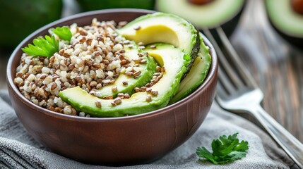 A nutritious bowl featuring quinoa, avocado slices, and garnished with fresh herbs, perfect for a healthy meal option.