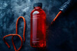 © JKIU - A sports drink bottle with a modern design, set next to a high-intensity workout rope and a stopwatch, focusing on refreshing hydration and endurance