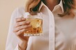 © Alla - A woman holding a glass of alcohol, possibly enjoying a relaxing moment