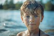 © Alla - A young boy playing in the water with wet hair and blue eyes