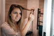 © diy13 - Girl using round brush hair dryer to style hair at mirror in an easy way at home