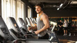 © Home-stock - Man athlete wearing wireless headphones, running on treadmill at gym, enjoy doing cardio training, panorama with copy space