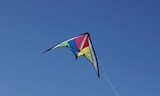 cometa multicolor volando al viento bajo un cielo azul despejado nitido luminoso
