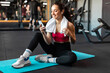 © Home-stock - Woman sitting on mat using smartphone and enjoying break, sporty lady resting during training and mobile phone