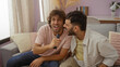 © Krakenimages.com - Two men singing together in a living room, enjoying a fun bonding moment as friends or family in a cozy indoor setting.