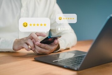 Fototapete - Person using a smartphone to leave a five-star review, with floating feedback icons and a laptop on a desk, symbolizing online reviews, testimonial and customer satisfaction.