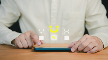 Fototapete - Customer using a smartphone select a happy face icon from a feedback scale with emoji options, symbolizing customer satisfaction, review, and positive user experience in an online feedback system.
