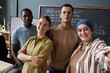 © Seventyfour - Smiling Muslim woman snapping selfie with diverse team of English teachers posing against blackboard in classroom of language school