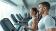 © Preeyanuch - A focused man and woman exercising on treadmills in a modern gym, promoting health and fitness lifestyles.
