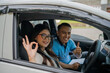 © Odua Images - A student and instructor celebrate the successful completion of a driving lesson