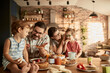 © Davor - Happy family enjoying breakfast together in cozy kitchen