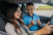 © Odua Images - A couple joyfully sharing a moment while driving down a scenic road, enjoying the ride