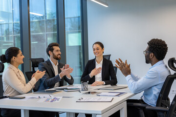 Wall Mural - A diverse group of professionals is seen applauding during a successful business meeting. The office setting reflects teamwork, motivation, and corporate culture, highlighting collaboration.