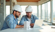 © Radorog. - two working architects in white helmets are working with a laptop