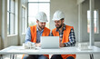 © Radorog. - two working architects in white helmets are working with a laptop